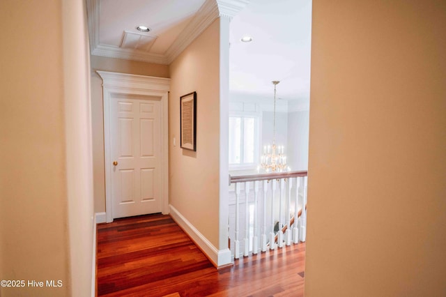 corridor with wood finished floors, baseboards, a chandelier, ornamental molding, and recessed lighting