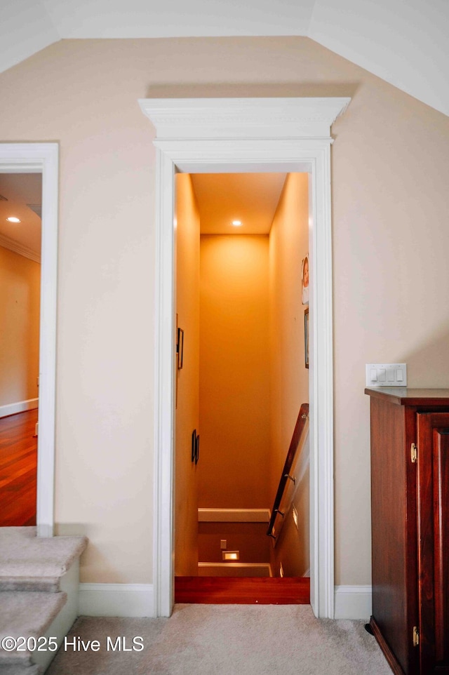 stairs featuring baseboards and vaulted ceiling
