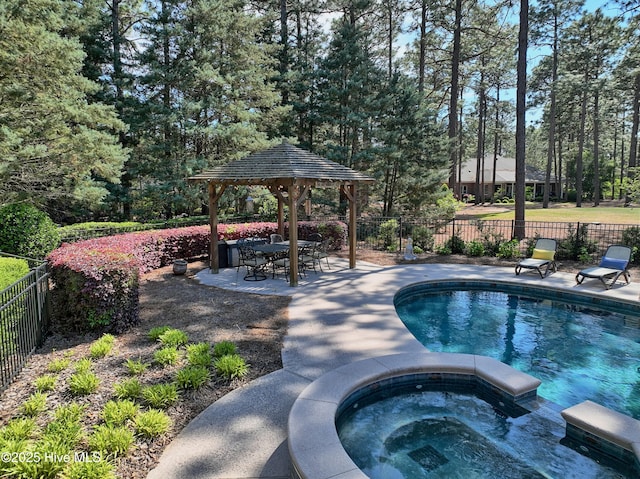 view of swimming pool with a gazebo, a pool with connected hot tub, a fenced backyard, and a patio area