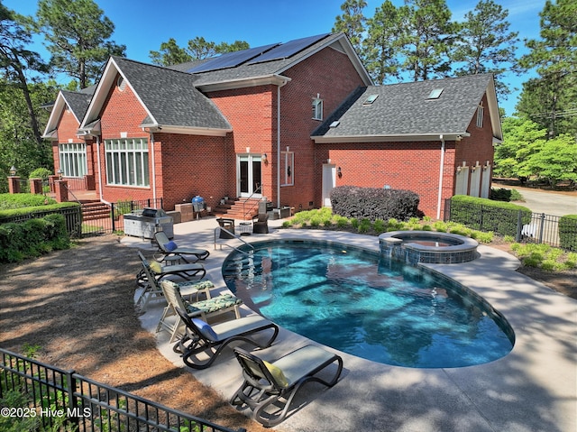 view of swimming pool with fence private yard, entry steps, a pool with connected hot tub, and a patio