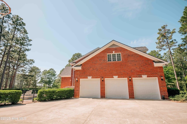 view of front of property with brick siding, a shingled roof, fence, and concrete driveway
