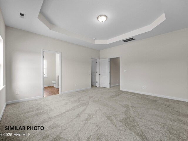 139 Tides End Dr, Holly Ridge, NC 28445 - unfurnished bedroom featuring visible vents, light carpet, baseboards, and a tray ceiling