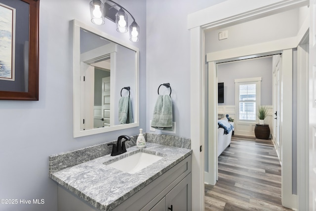 bathroom featuring vanity, wood finished floors, and connected bathroom