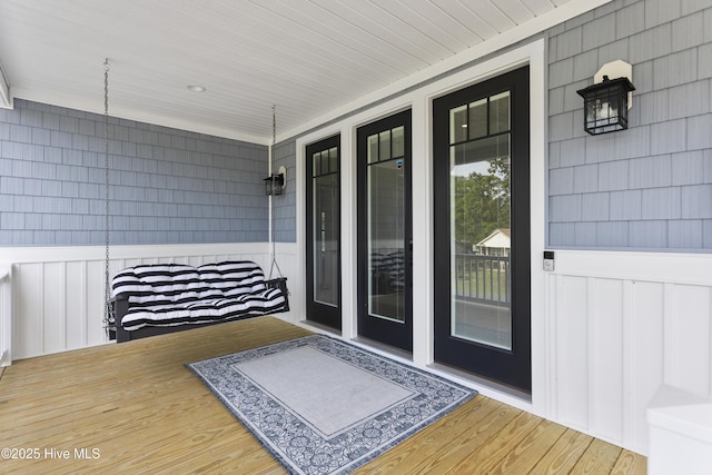 doorway to property with a porch and board and batten siding