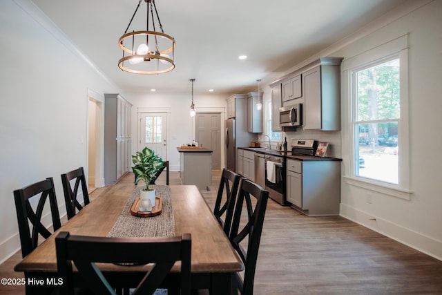 dining room featuring an inviting chandelier, recessed lighting, baseboards, and a healthy amount of sunlight