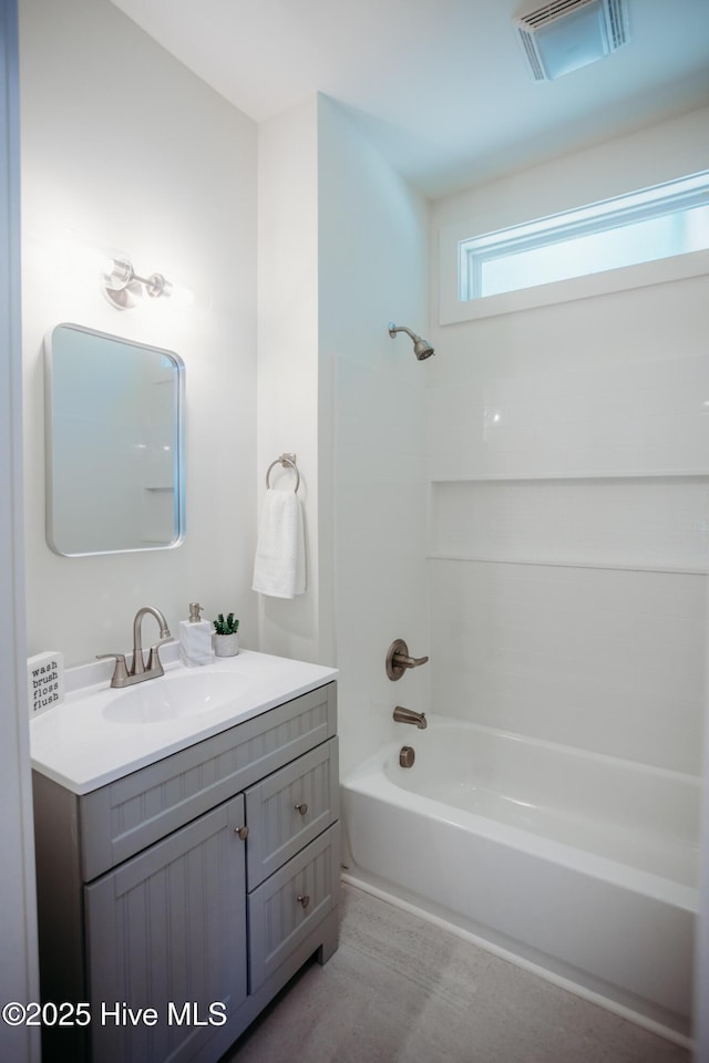bathroom featuring visible vents, tub / shower combination, and vanity