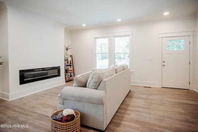 living area with crown molding, recessed lighting, baseboards, and light wood-type flooring
