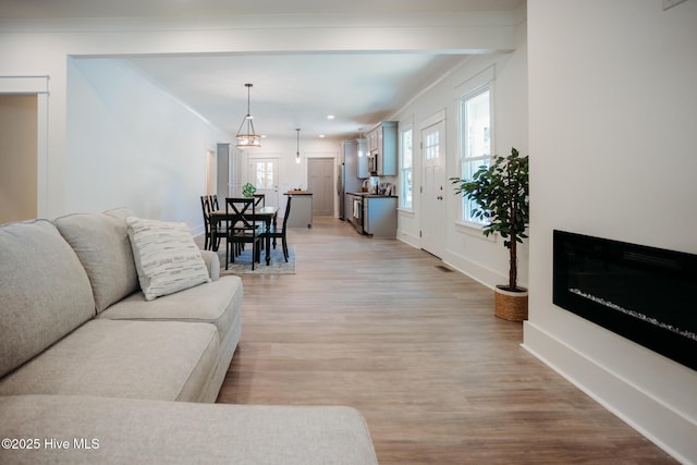 living room featuring baseboards, recessed lighting, light wood-style flooring, and visible vents