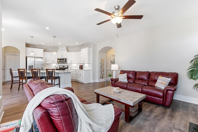 2226 Jasper Forest Trl, Winnabow, NC 28479 - living area with arched walkways, ceiling fan, baseboards, dark wood-type flooring, and recessed lighting