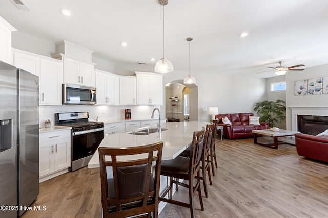 2226 Jasper Forest Trl, Winnabow, NC 28479 - kitchen with stainless steel appliances, a sink, arched walkways, decorative backsplash, and light countertops