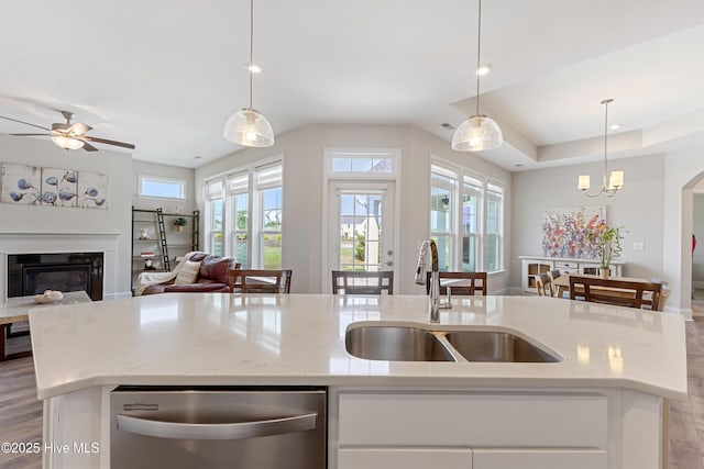 2226 Jasper Forest Trl, Winnabow, NC 28479 - kitchen with stainless steel dishwasher, a sink, open floor plan, an island with sink, and a glass covered fireplace