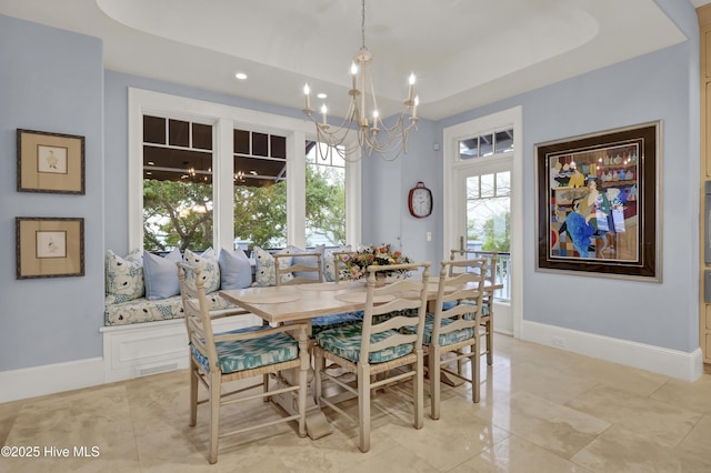 dining space with baseboards, recessed lighting, a tray ceiling, and a notable chandelier