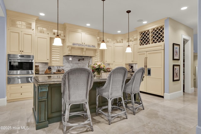 kitchen featuring a kitchen island with sink, stainless steel oven, tasteful backsplash, a warming drawer, and paneled fridge