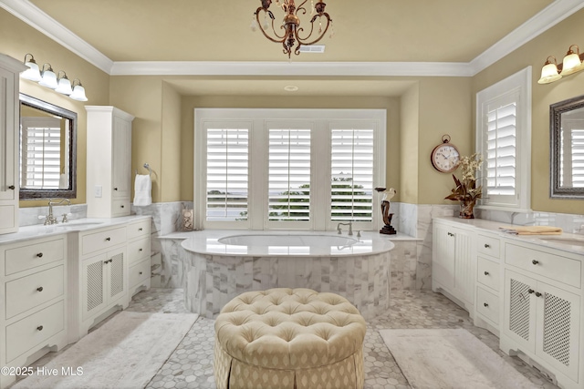bathroom featuring a bath, visible vents, crown molding, wainscoting, and vanity
