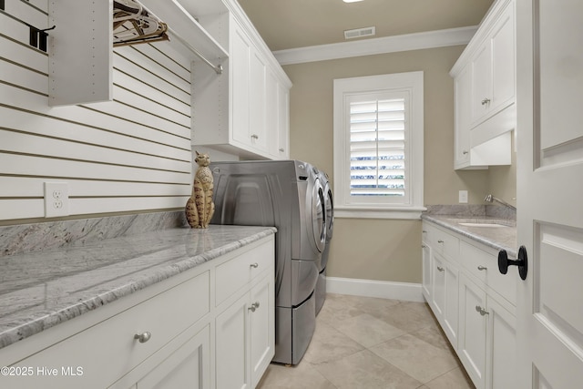 laundry area featuring visible vents, crown molding, washer and clothes dryer, a sink, and cabinet space