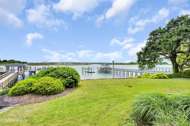 dock area with a lawn and a water view