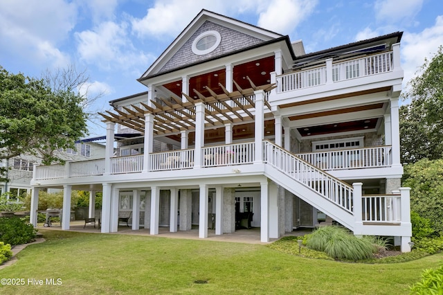 rear view of property featuring a balcony, a deck, stairs, a patio area, and a yard