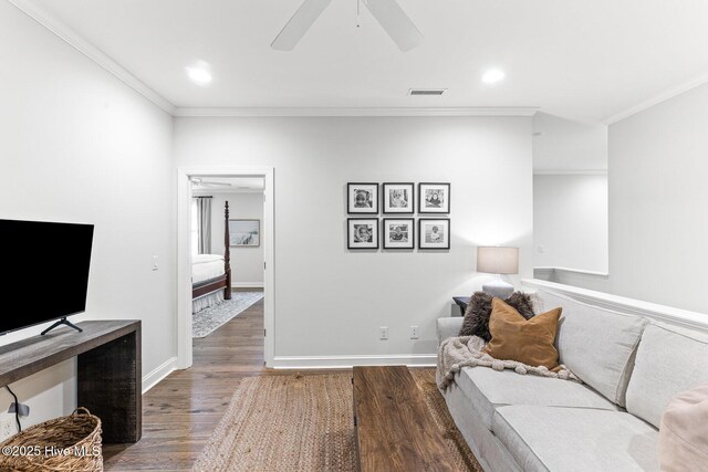 living room featuring ceiling fan, ornamental molding, wood finished floors, and visible vents