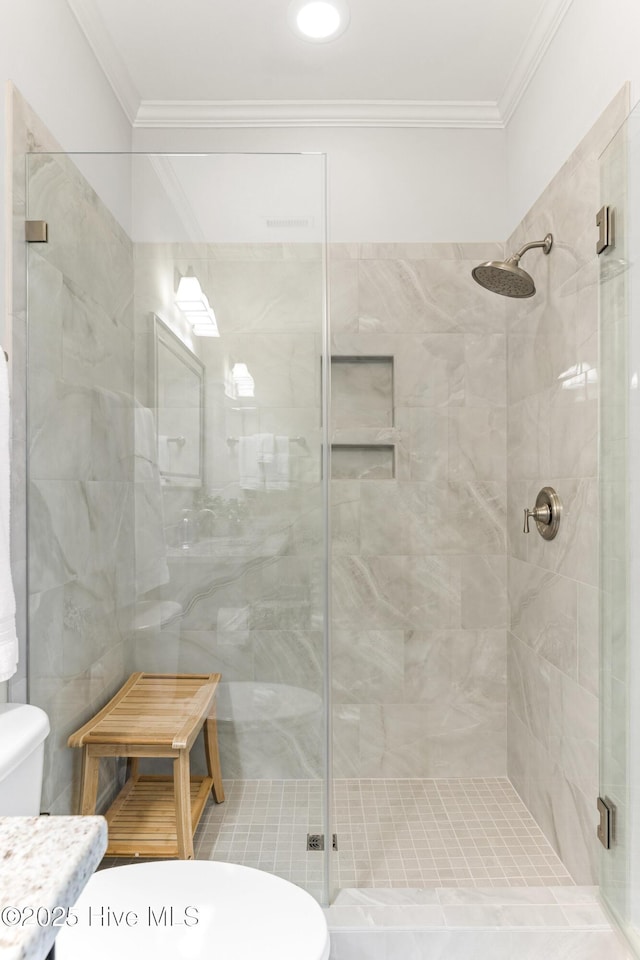 full bath with ornamental molding, a shower stall, and toilet