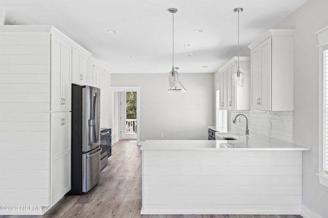 kitchen with a sink, appliances with stainless steel finishes, white cabinets, and decorative backsplash