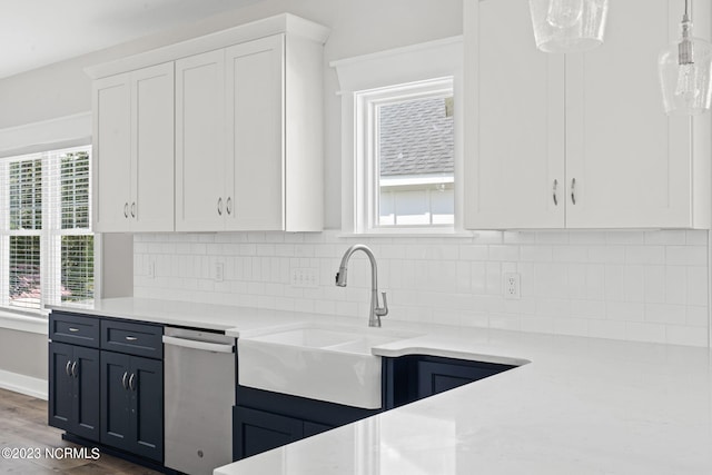kitchen featuring light countertops, white cabinets, a sink, and dishwasher