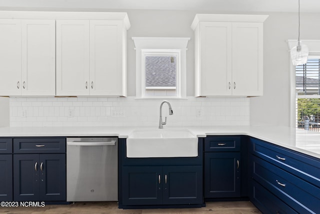 kitchen featuring blue cabinetry, tasteful backsplash, dishwasher, a sink, and white cabinetry