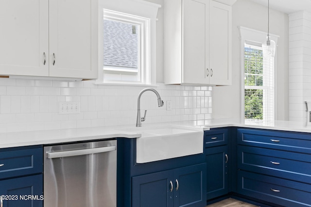 kitchen with blue cabinetry, a sink, and dishwasher