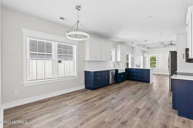 kitchen featuring light wood finished floors, blue cabinetry, a peninsula, stainless steel appliances, and visible vents