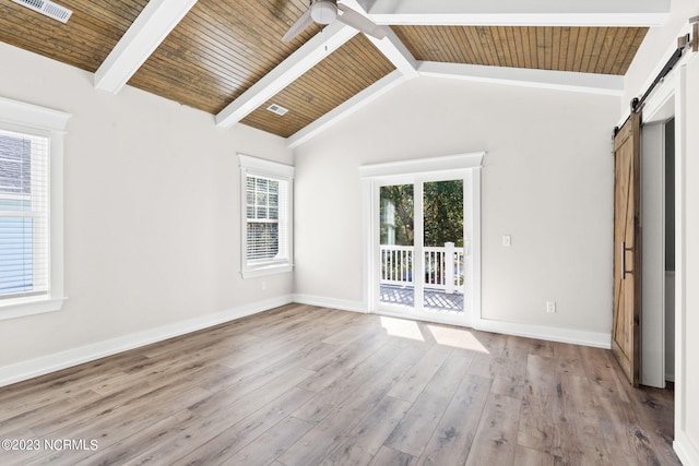 unfurnished room featuring visible vents, wood finished floors, baseboards, ceiling fan, and a barn door