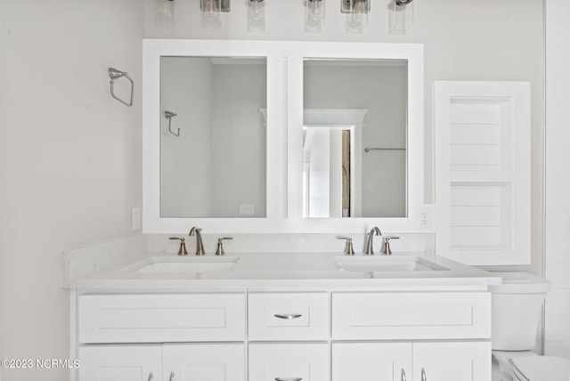 full bathroom with double vanity, toilet, and a sink