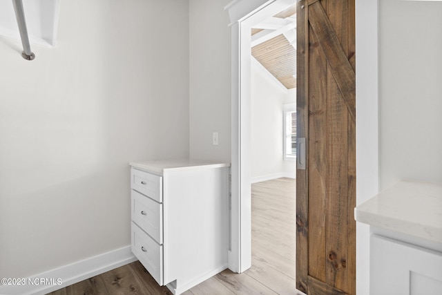 hall featuring light wood-style floors and baseboards
