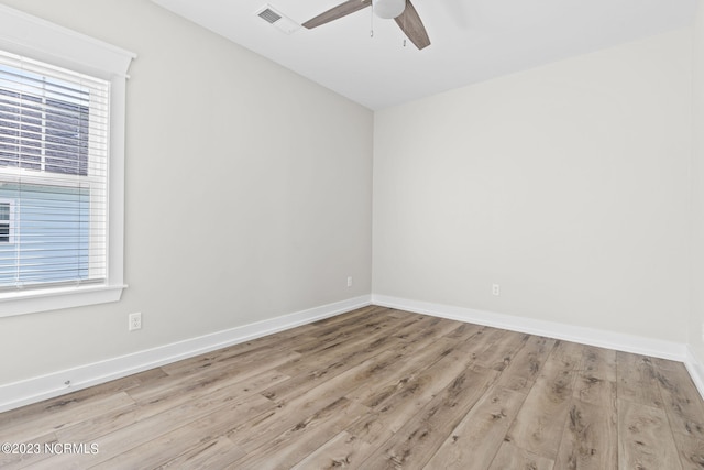 spare room featuring a ceiling fan, baseboards, visible vents, and wood finished floors