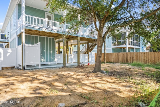 back of property with stairway, fence, central AC unit, and a wooden deck