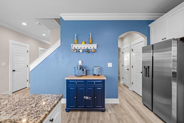 kitchen with light wood-style floors, stainless steel fridge with ice dispenser, crown molding, and blue cabinetry