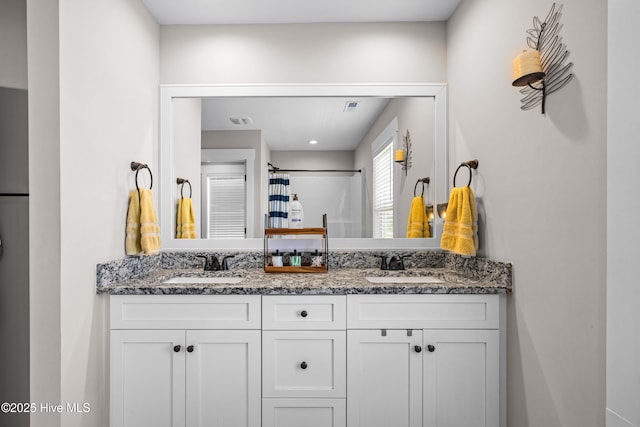 bathroom featuring a sink, double vanity, a shower with shower curtain, and visible vents