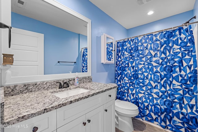 full bath featuring toilet, a shower with curtain, wood finished floors, vanity, and visible vents