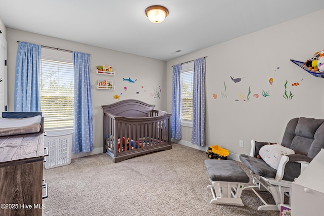 carpeted bedroom with baseboards, a crib, and visible vents