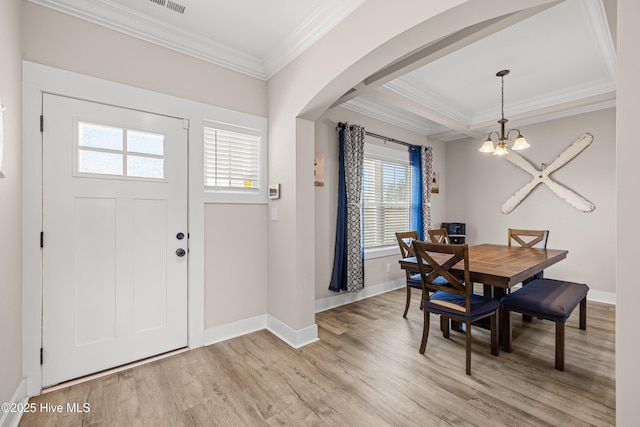 entrance foyer featuring ornamental molding, a wealth of natural light, a notable chandelier, and light wood-type flooring