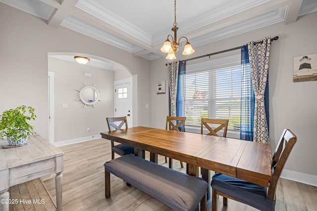dining room with light wood-style flooring, beam ceiling, arched walkways, a chandelier, and ornamental molding