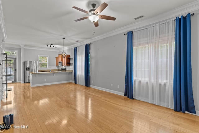 unfurnished living room featuring crown molding, ceiling fan, light wood-type flooring, and baseboards