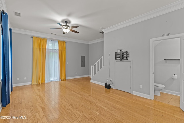 unfurnished living room featuring stairway, ceiling fan, crown molding, light wood-type flooring, and electric panel