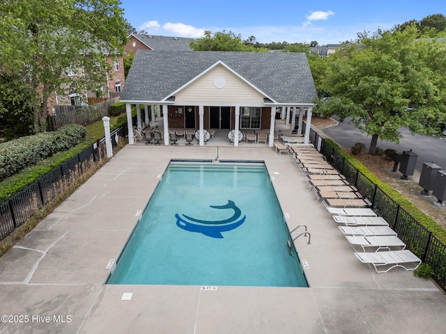 community pool featuring fence and a patio