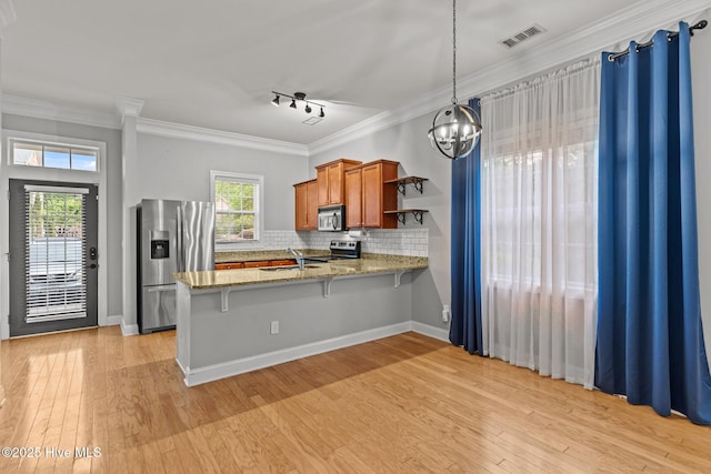 kitchen with stainless steel appliances, brown cabinetry, a sink, a peninsula, and open shelves
