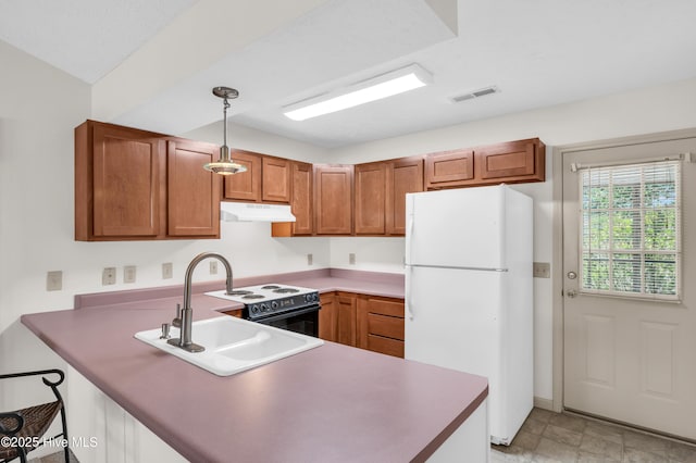 kitchen featuring freestanding refrigerator, a peninsula, range with electric stovetop, under cabinet range hood, and a sink
