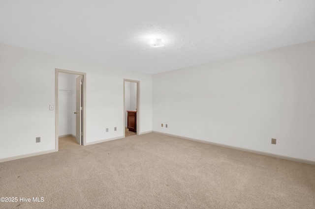empty room featuring baseboards and light colored carpet