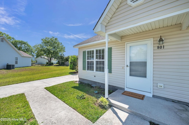 doorway to property featuring a yard and cooling unit