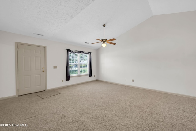 unfurnished room with a ceiling fan, visible vents, light colored carpet, baseboards, and lofted ceiling
