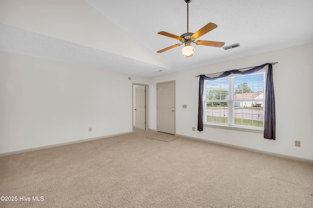 unfurnished room featuring visible vents, a ceiling fan, vaulted ceiling, and light colored carpet