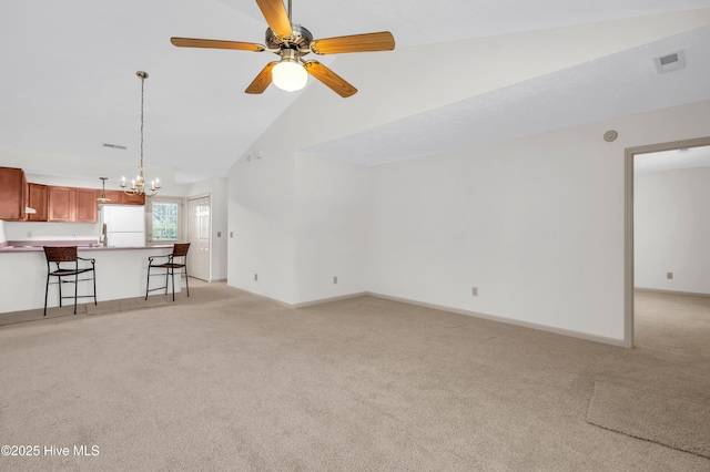 unfurnished living room featuring light colored carpet, baseboards, ceiling fan with notable chandelier, and visible vents