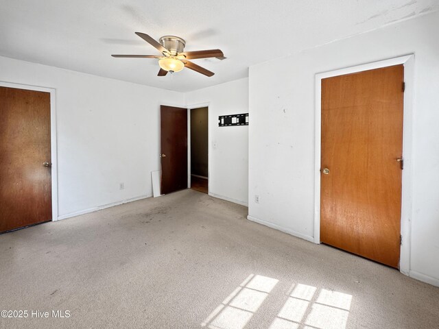 unfurnished bedroom with carpet floors, baseboards, and ceiling fan